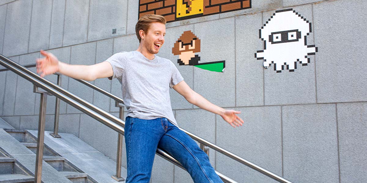 Digital specialist inom utveckling och programmering åker rutschkana på ledstång.