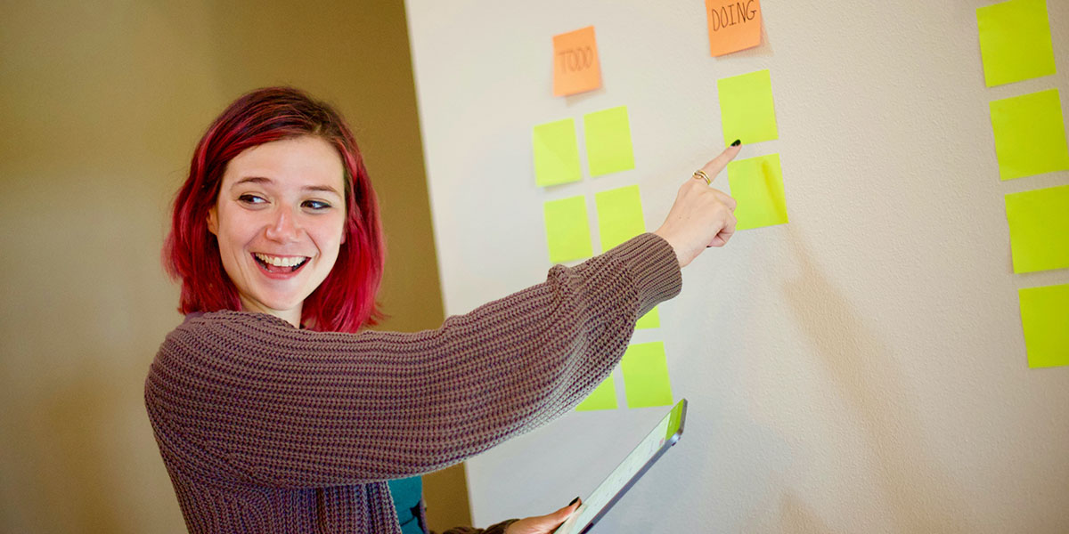 Kvinna visar agil metodik med post-it-lappar - en symbol för agil rekrytering
