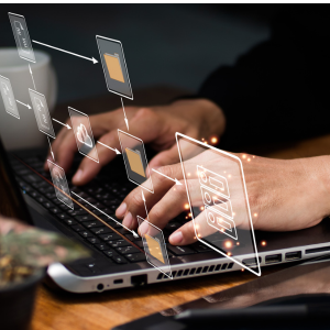 En person som sitter och jobbar på sin dator med olika dokument.