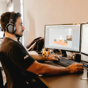 En kille som jobbar som spelekonomidesigner, framför sin dator.