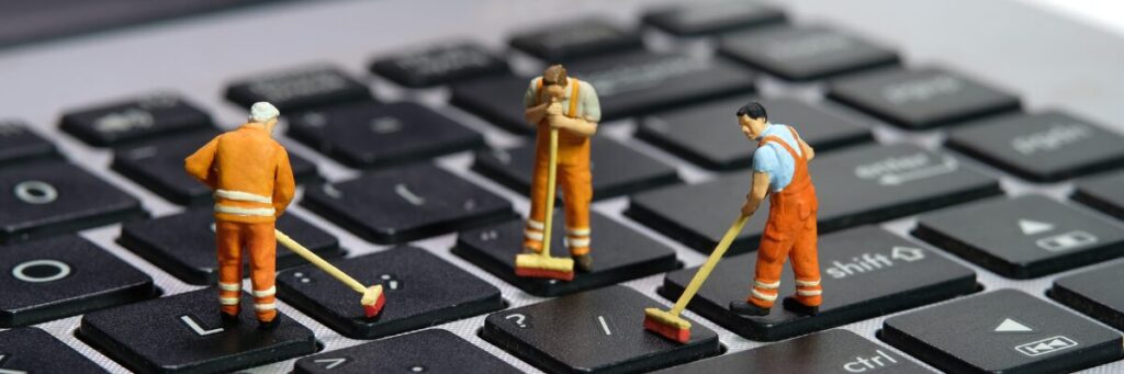 Tre killar som står och städar på tangentbordet