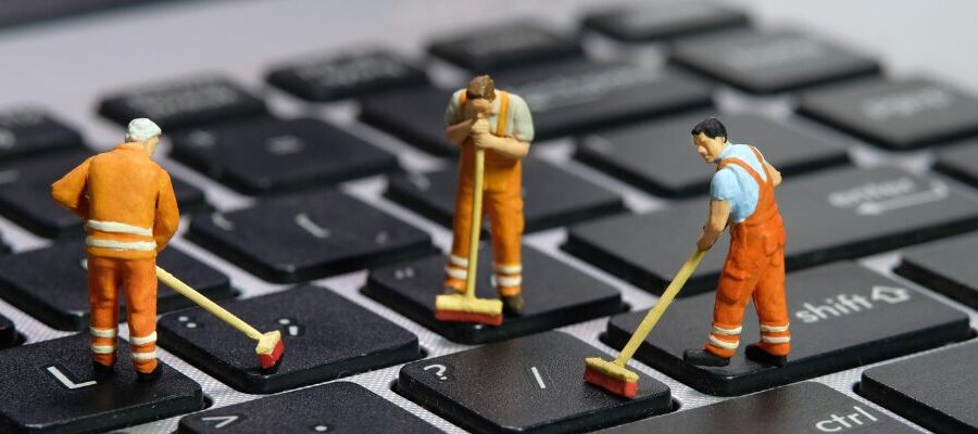 Tre killar som står och städar på tangentbordet